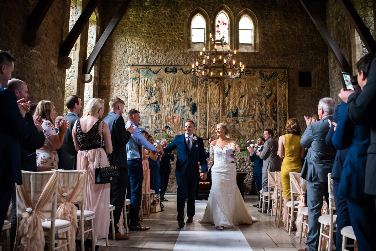 Paul & Lexy are photographed walking down the aisle after their ceremony in Allington Castle in Kent