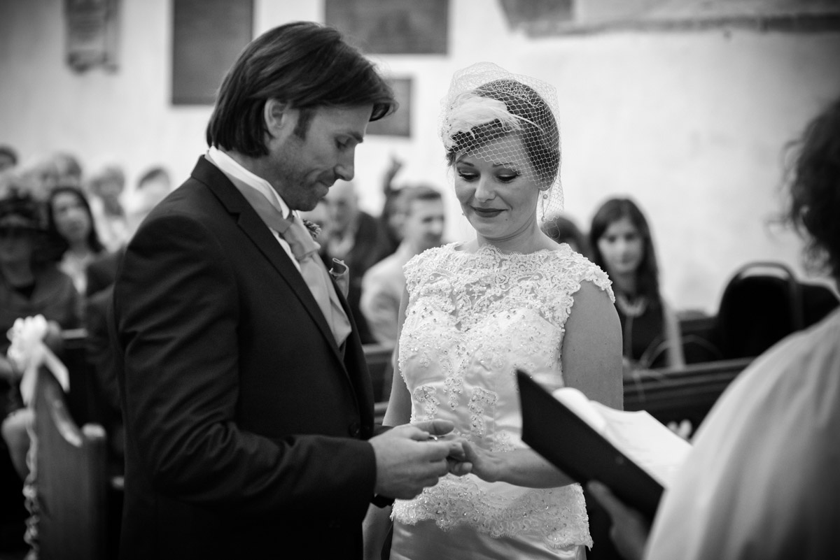 John & Ania are photographed exchanging rings during their Kent church wedding ceremony
