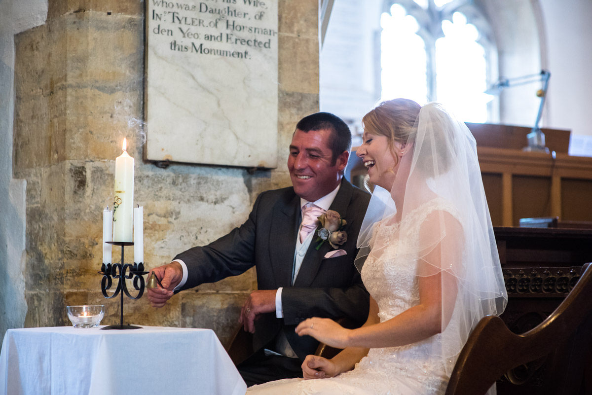 Kif and Becky are photographed putting out the candles during their church wedding ceremony