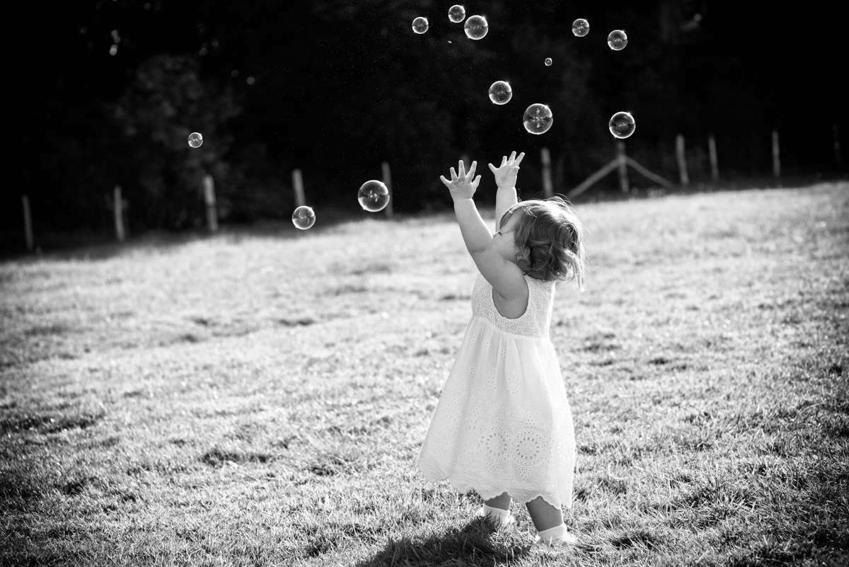 Little girl is photographed chasing bubbles during Kif and Becky's wedding reception in Kent
