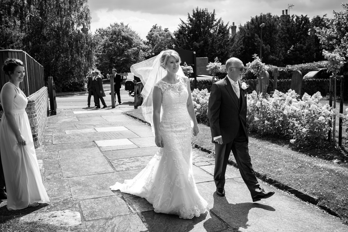 Black and white photograph of Becky as she arrives for her Kent wedding in Marden Church