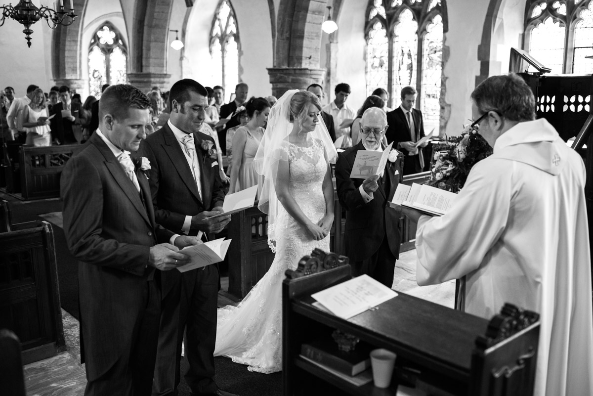 Black and white wedding photograph of Kif & Becky during their church ceremony