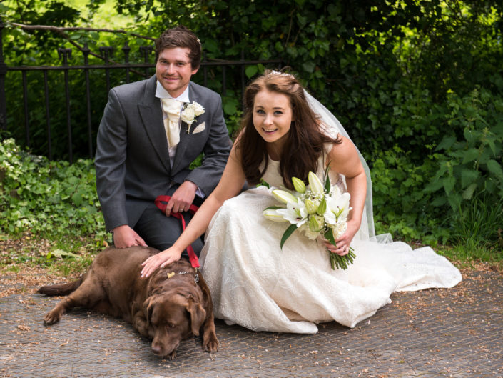Sam and Harriet photographed with their labrador on their wedding day at Headcorn Church in Kent