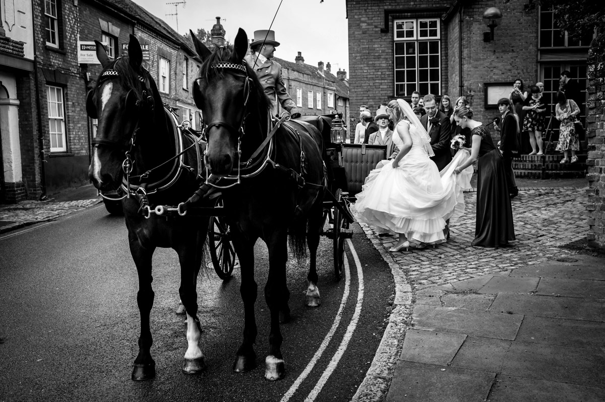 caroline steps up into horse carriage after her wedding ceremony