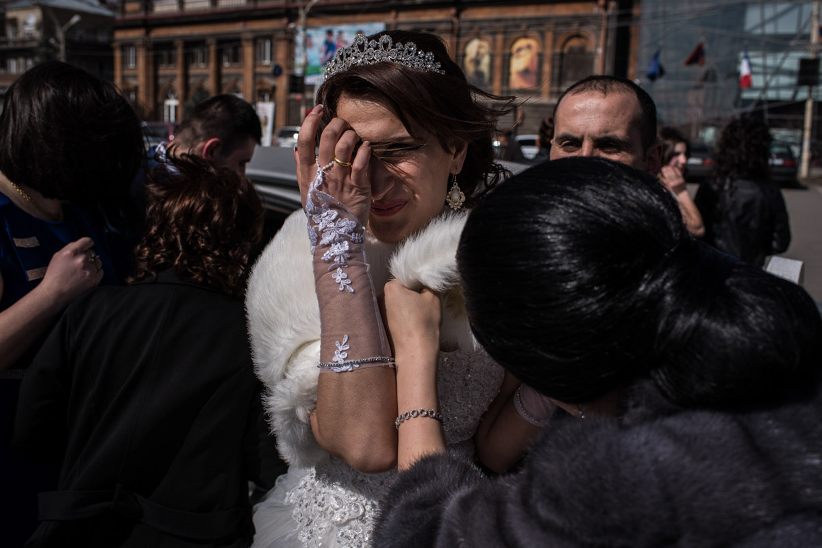 Armenian bride pushes hair from her face before going in for her wedding ceremony