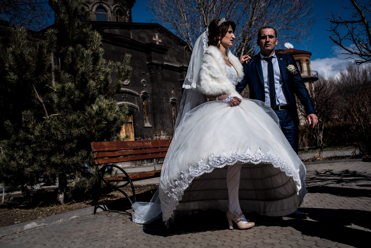 photograph of bride looking like she's on one leg after her wedding in church in gyumri in armenia