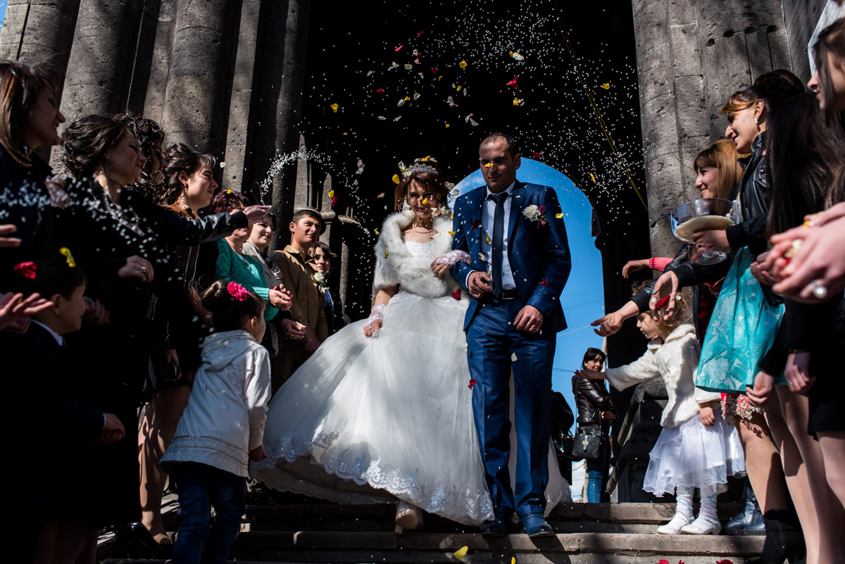 confetti is thrown over bride and groom after their church wedding ceremony in armenia