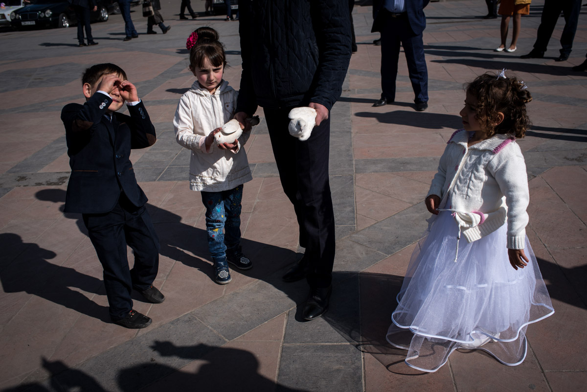young children and white doves photographed after wedding ceremony in gyumri in armenia