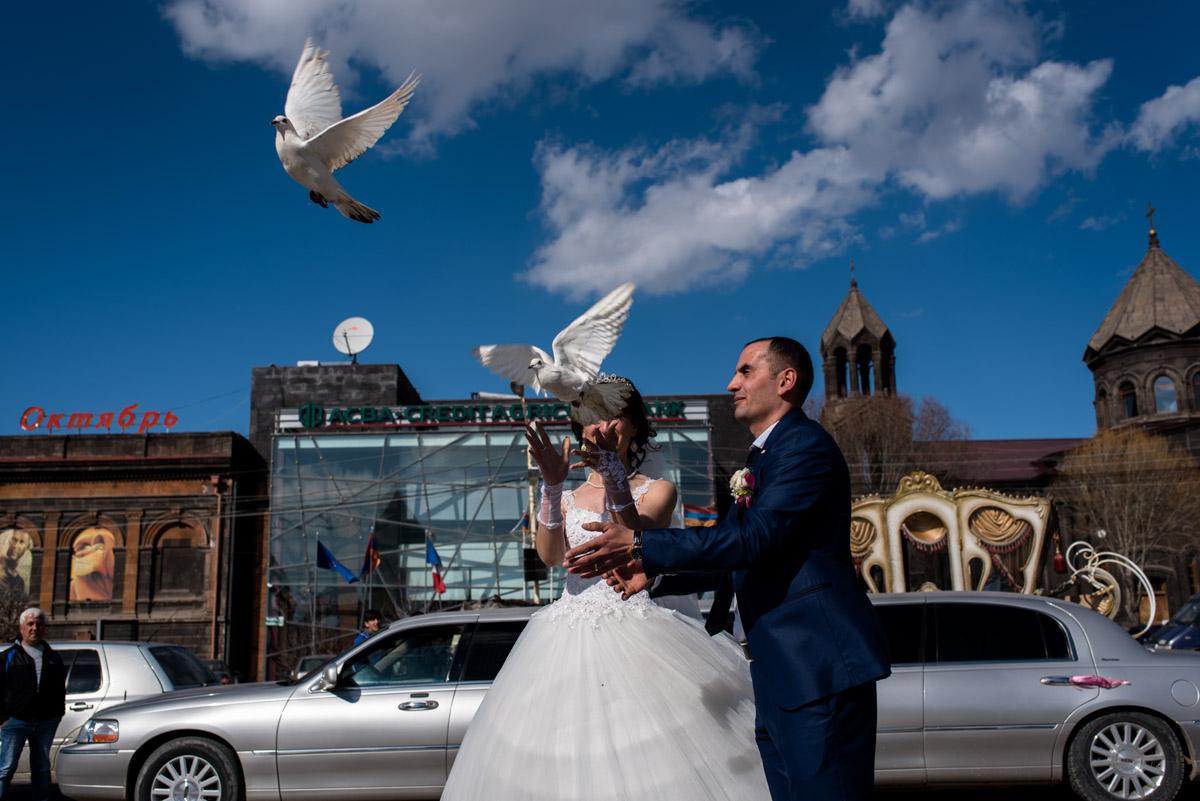 armenian newly weds release two white doves after their wedding ceremony in Gyumri in armenia