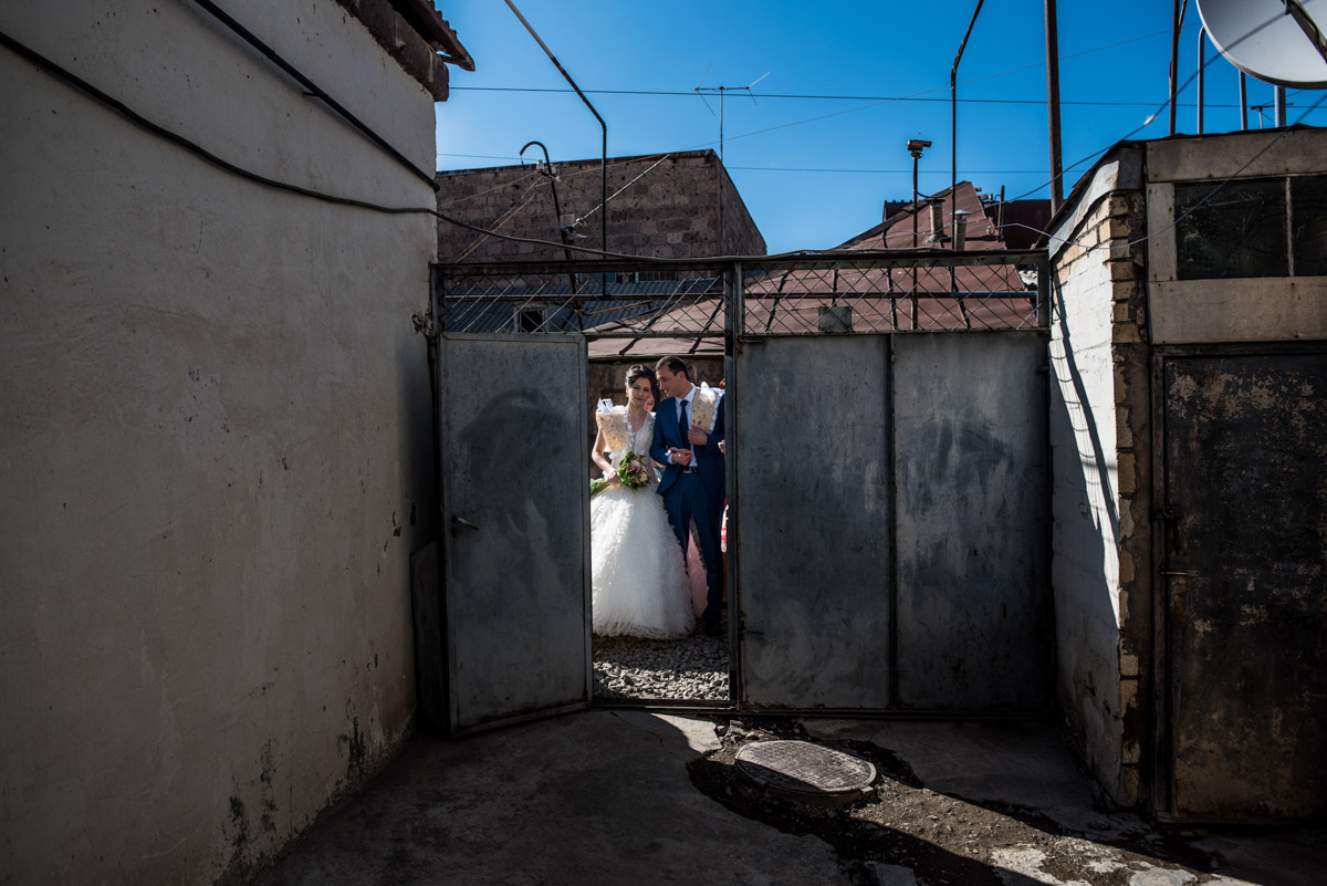 armenian bride and groom are photographed at the door to their home on their wedding day