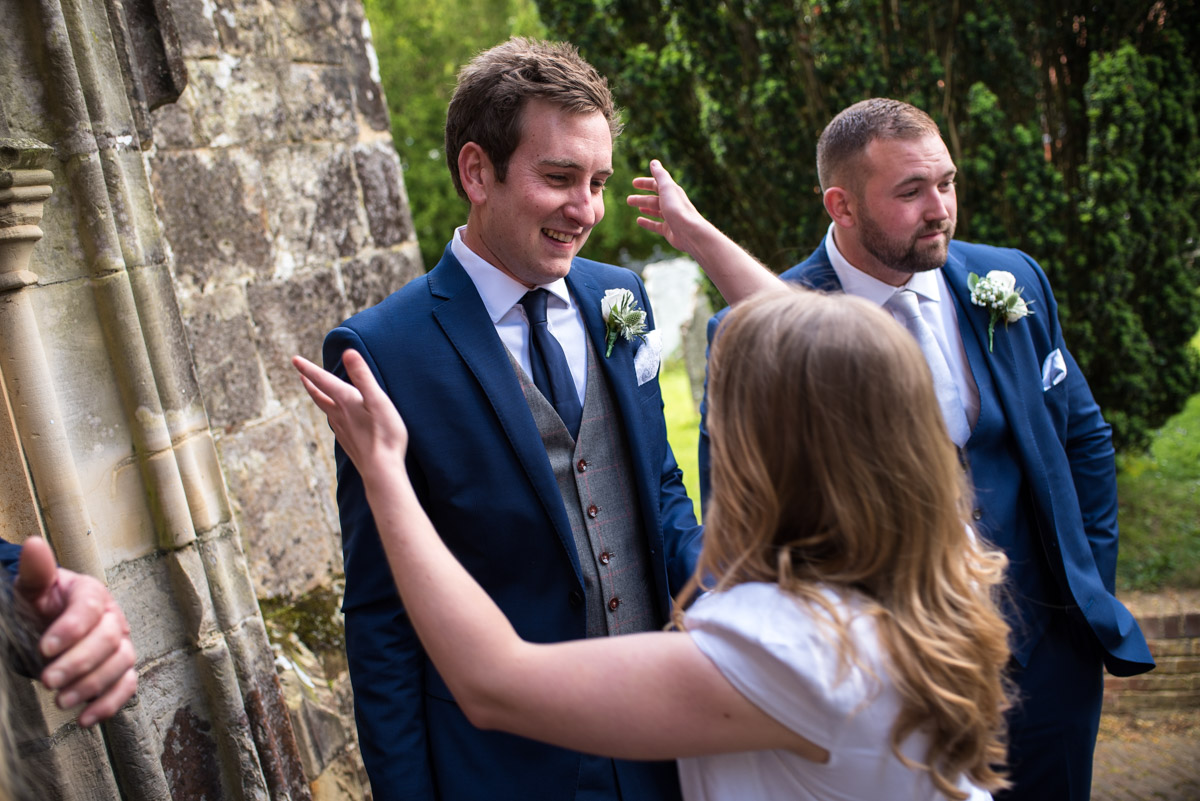 James is greeted warmly by wedding guest outside Kent church
