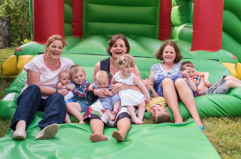 Photograph of Georgia and her sisters with their children on the bouncy castle in garden in Bethersden in Kent