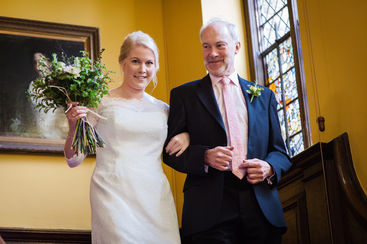 Father and bride walk down stairs at Boughton Monchelsea for wedding ceremony