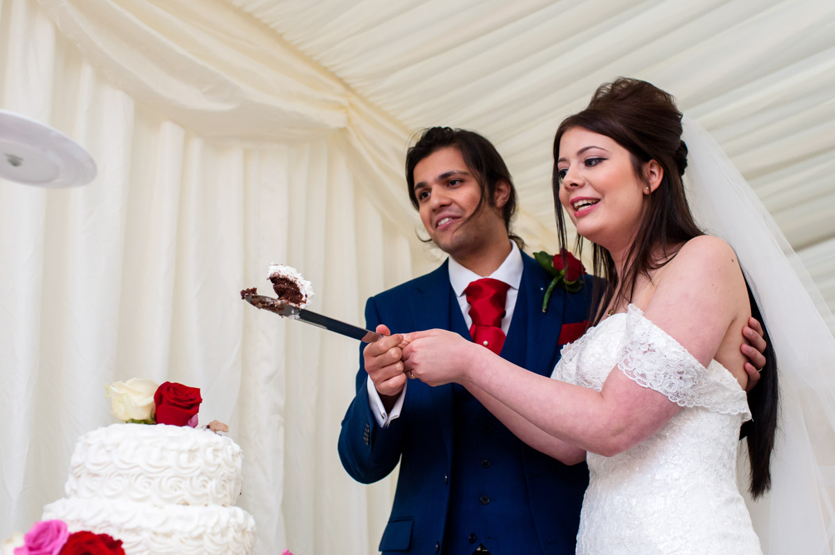 Photograph of Marianne and Seb cutting their wedding cake