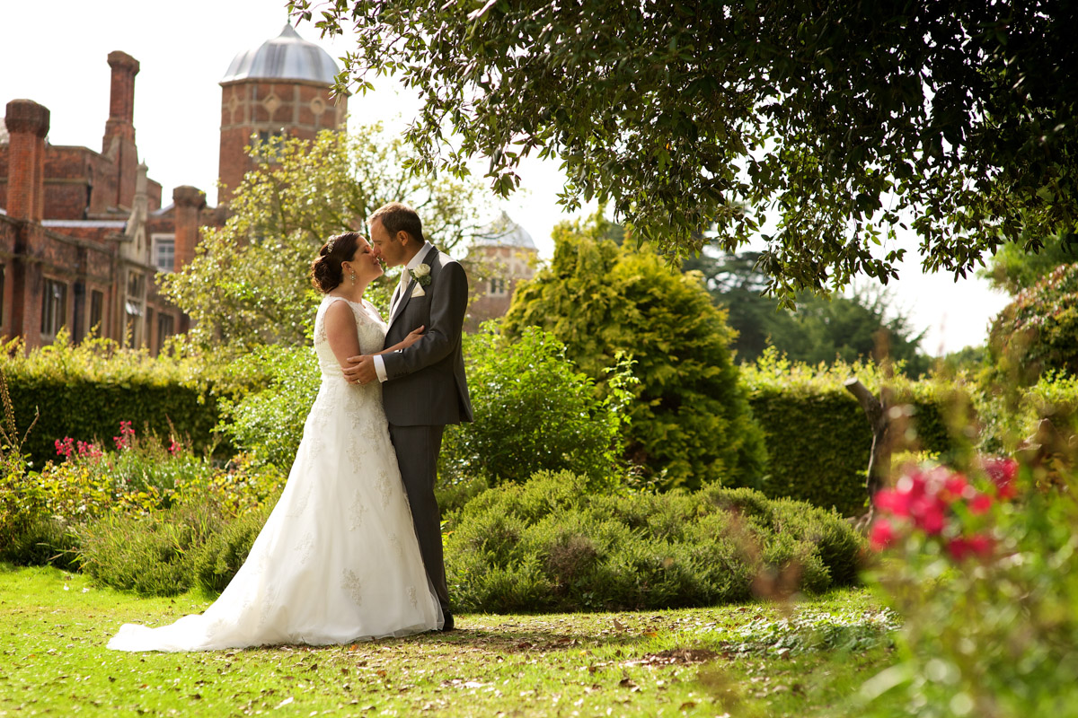 Photograph of andrea and tim on their wedding day with cobham hall in kent in the background