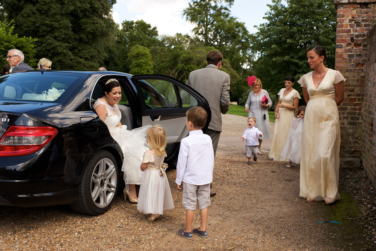 Andrea steps out of the car at cobham hall on her wedding day