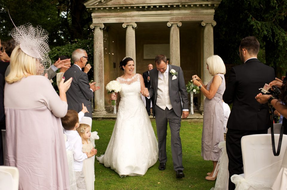 andrea and tim have confetti thrown on them at cobham hall