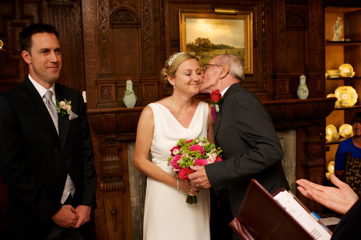 gail dad kisses her cheek as he gives her away during her wedding ceremony at never castle in kent