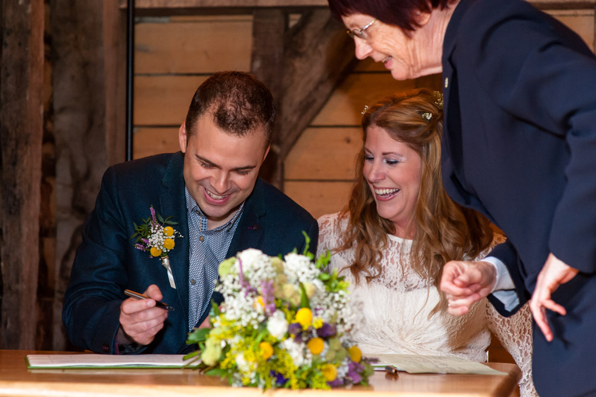 Ratsbury Barn wedding, Corinne and Doug sign the wedding register