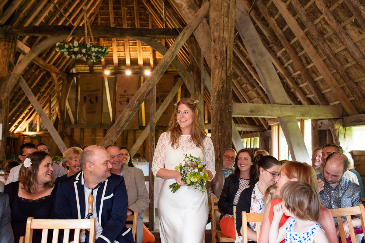 Ratsbury Barn wedding photography of Corinne walking up the aisle for her wedding ceremony in rats bury Barn in Kent