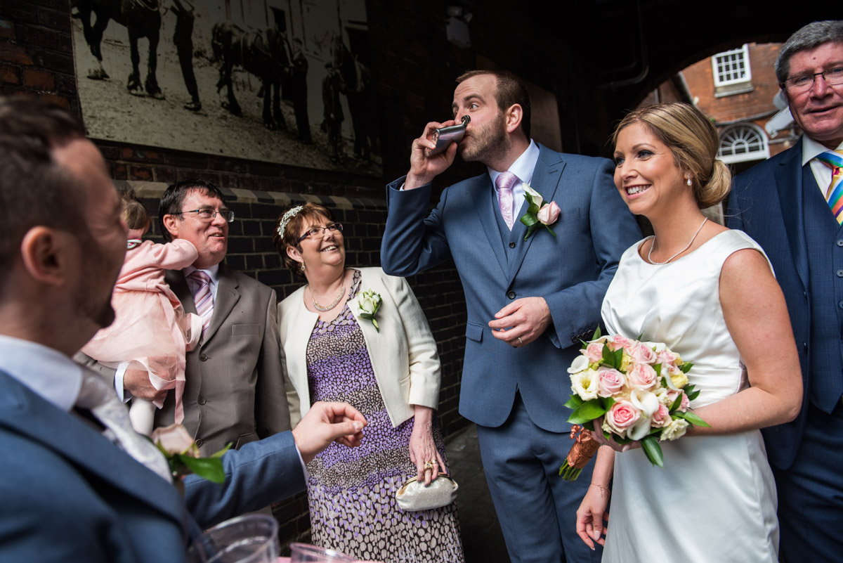 Mike drinks from hip flask while wedding photographs are taken
