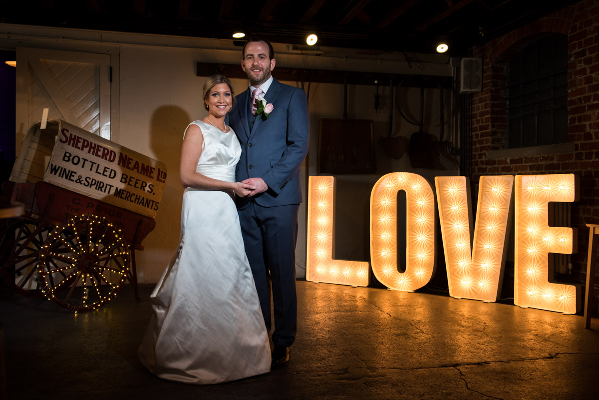 Photograph of Mike and Louise in front of their 'Love' sign at The Brewery in Faversham Kent