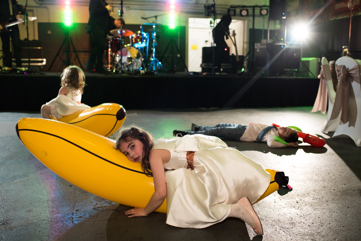 Kids at Mike and Louise's wedding are photographed playing on inflatables