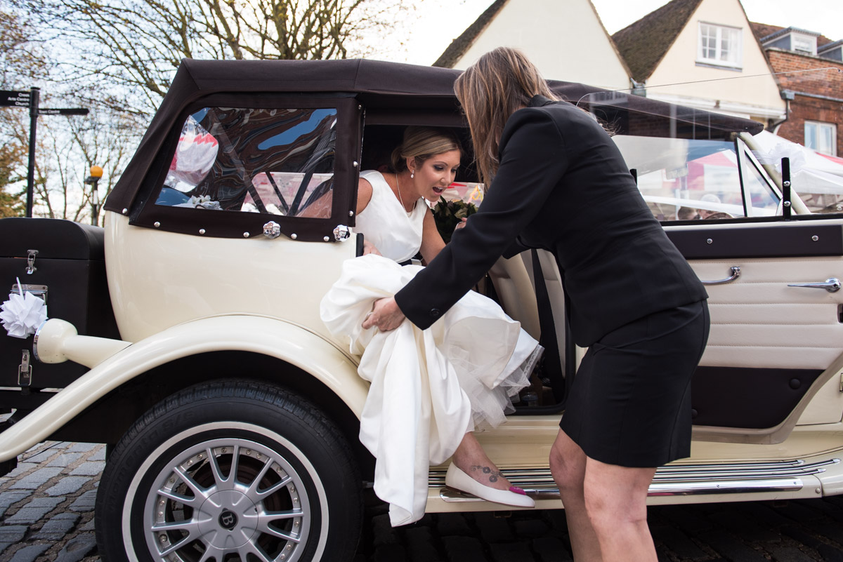 Louise is helped out of the wedding car