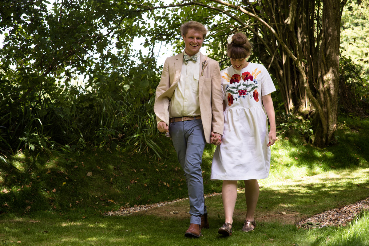 Seb and Brogan are photographed walking down to their wedding celebration in the woods