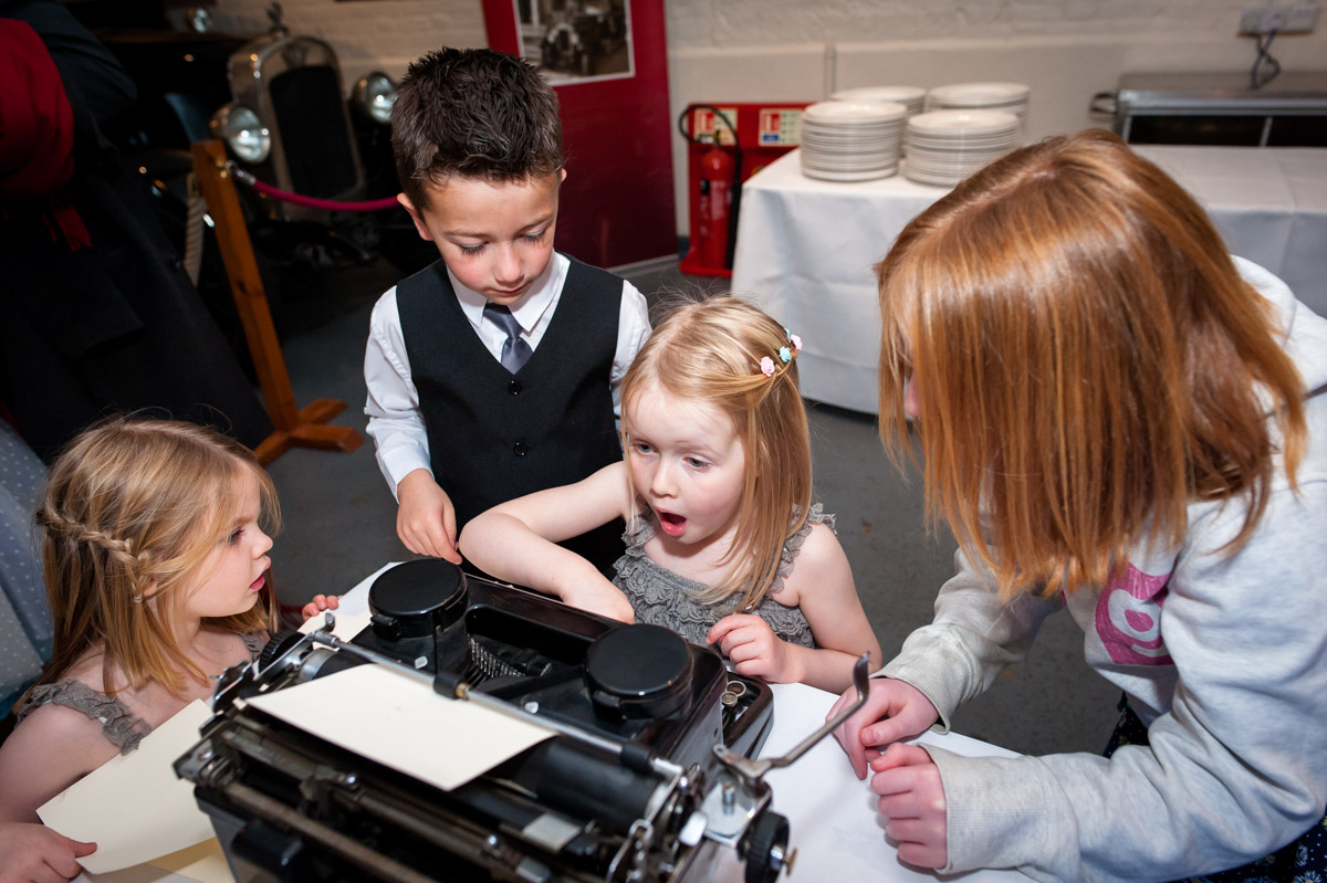 Children at laura and Daniles wedding are photographed playing with type writer