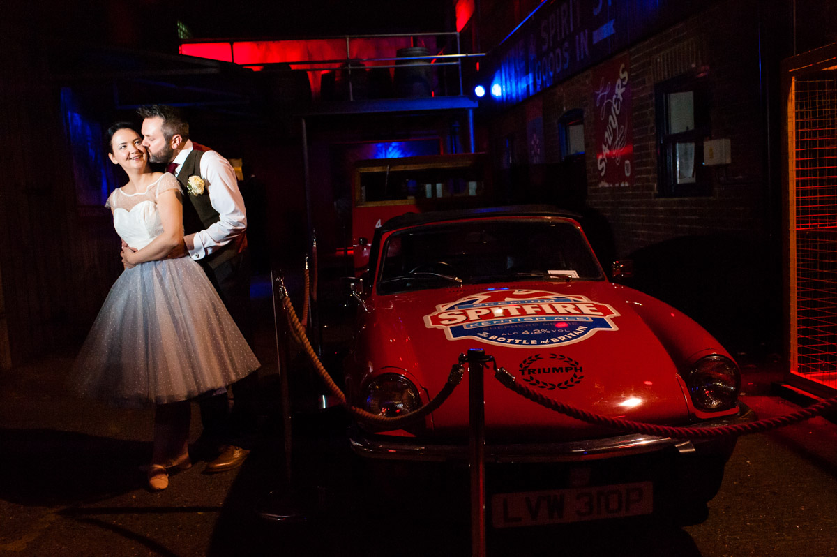 wedding portrait photograph of Laura and Daniel by the Spitfire car at shepherd Neame in Kent
