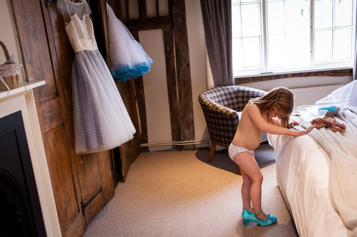 Photograph of flower girl trying on Laura's wedding shoes