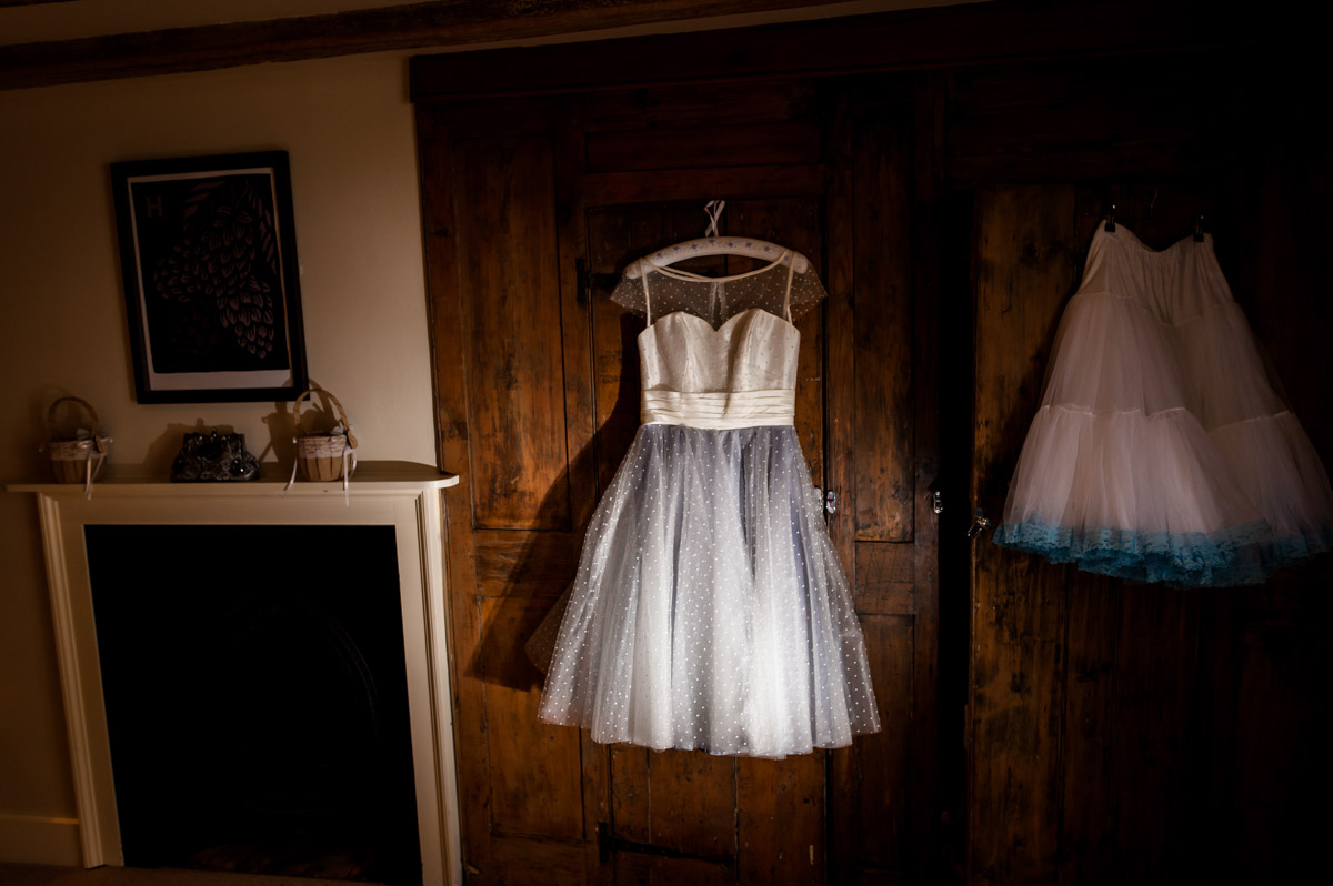 Lauras wedding dress is photographed hanging up in the room