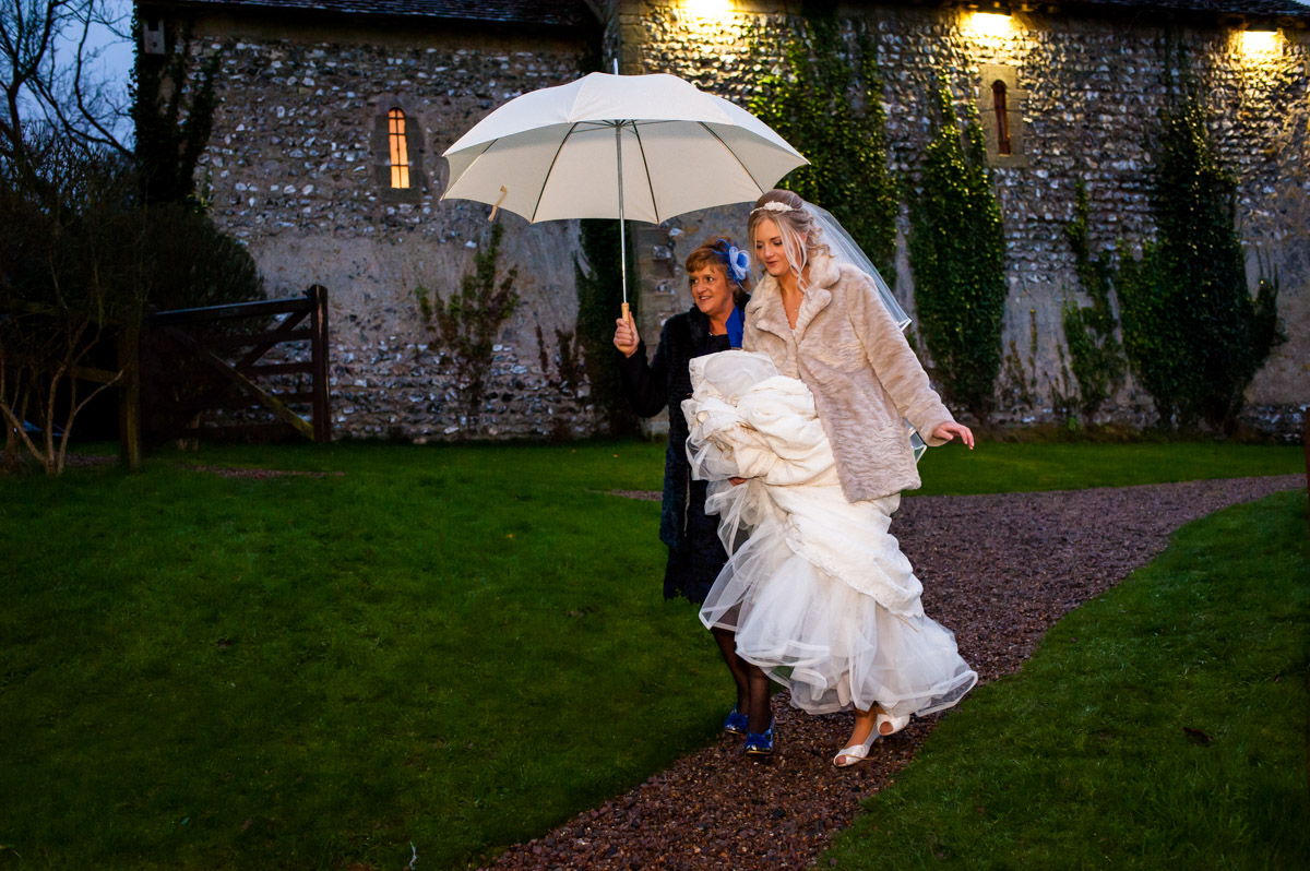 Mum shields sara from the rain with umbrella on her wedding day