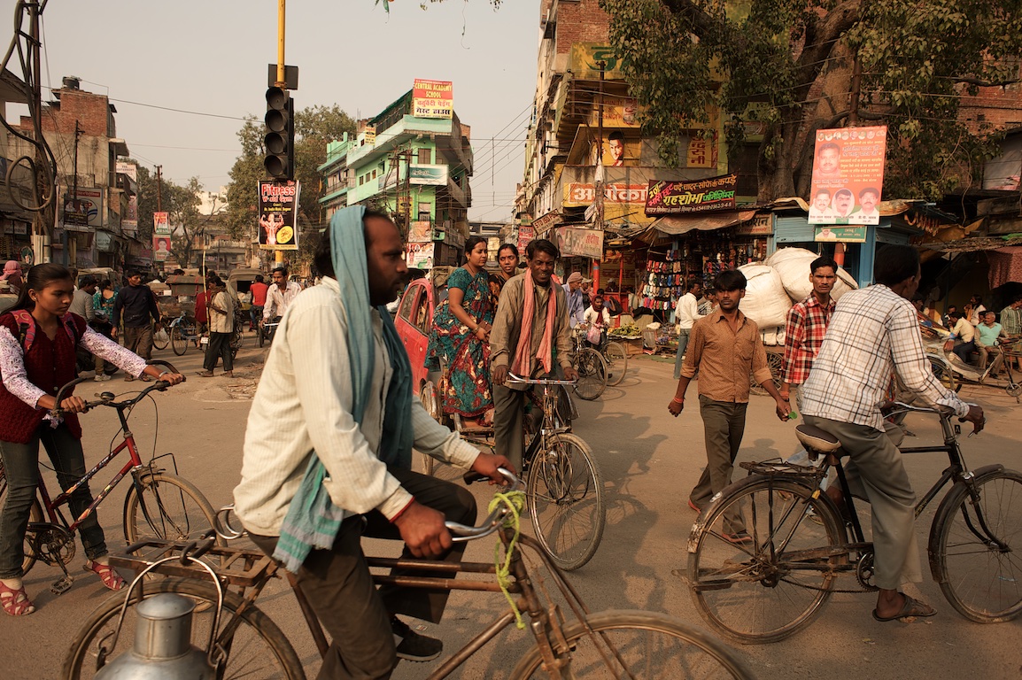 Photograph of people riding bicycles and walking in streets of varanasi