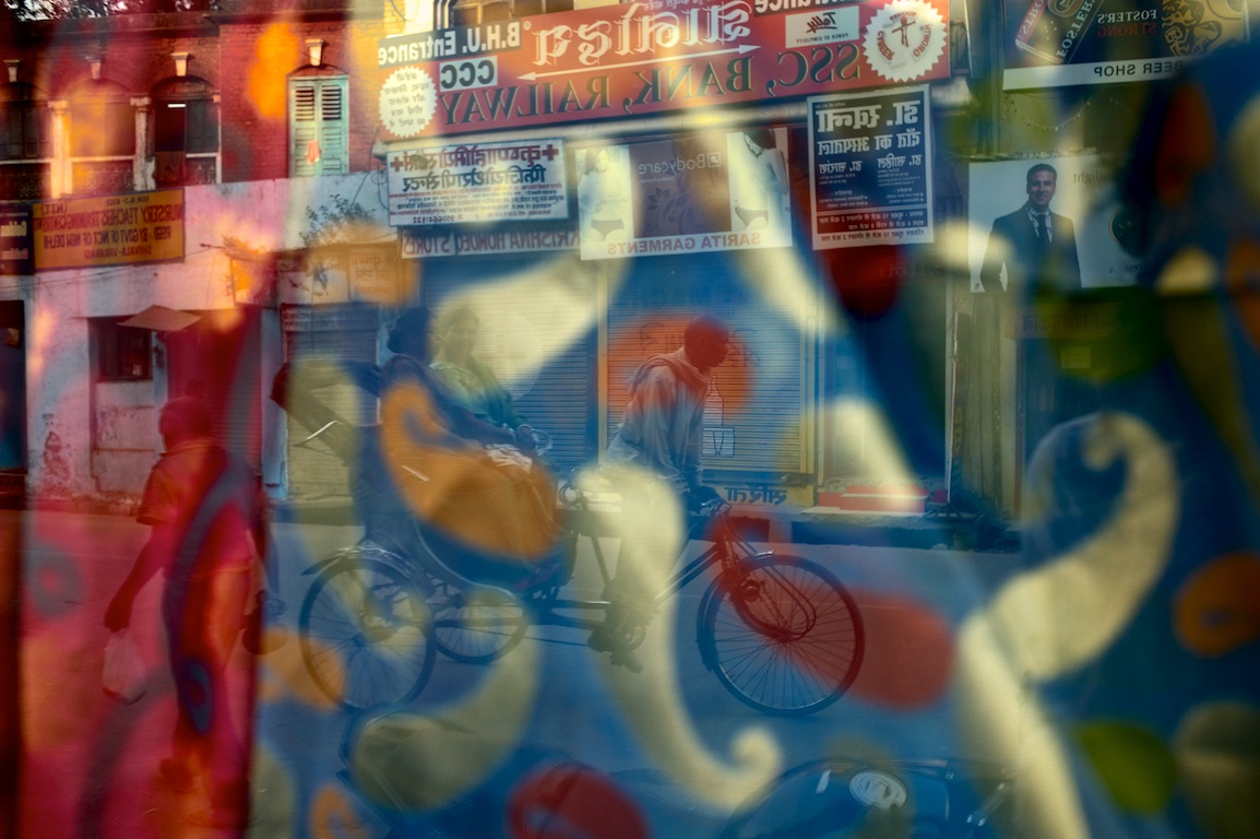 Photograph of reflection in window of fabric shop in varanasi