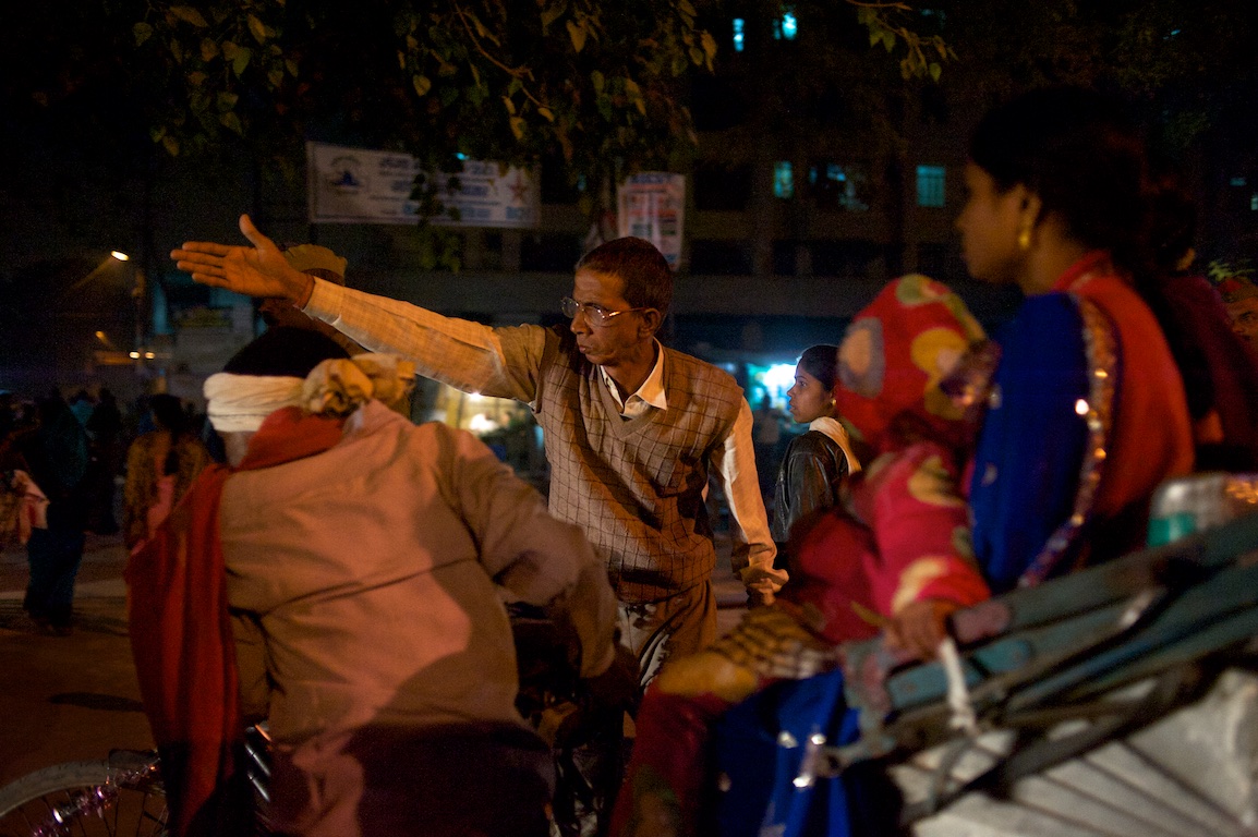 man indicates directions with his arm in traffic in varanasi