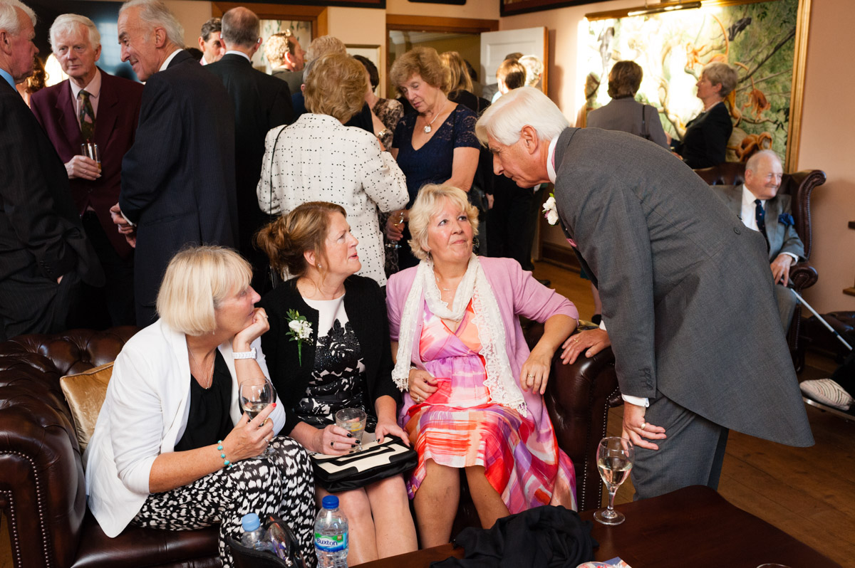 Dick talks to wedding guests in the bar at port lymph mansion wedding venue