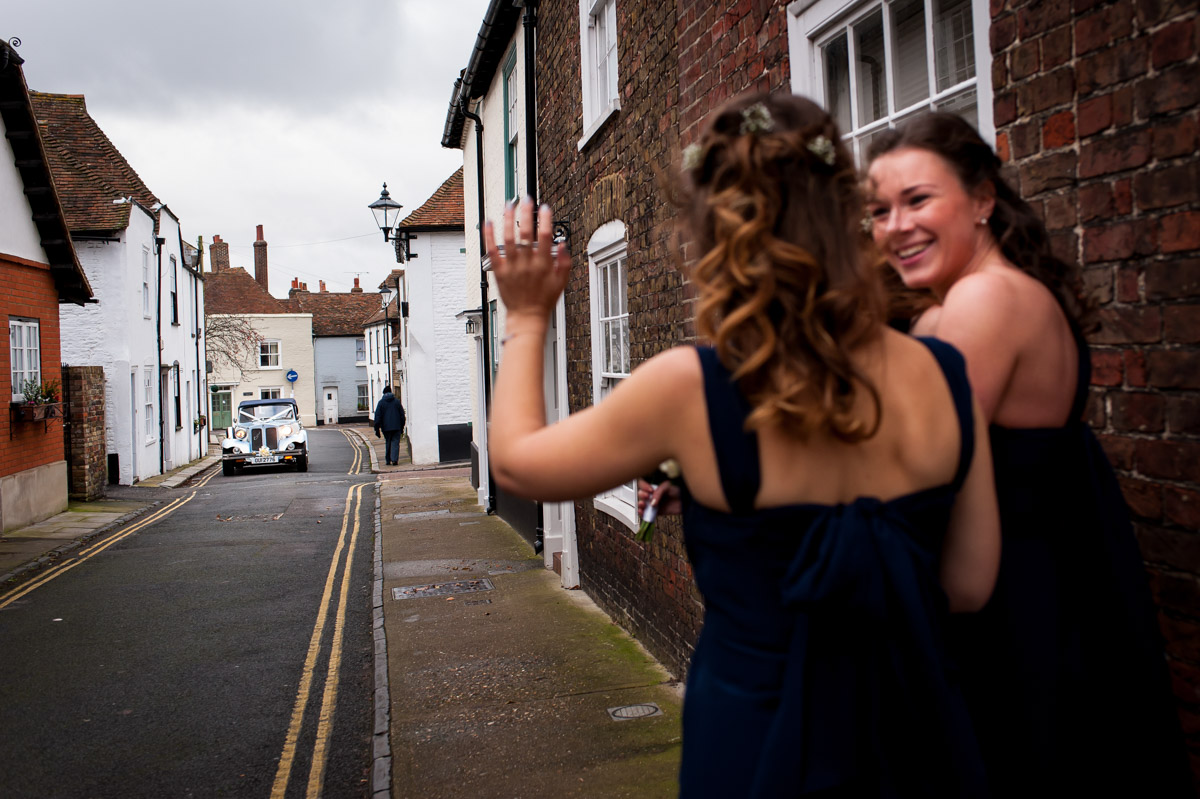 Bridesmaids wave to Emma as she arrives for her Kent church wedding