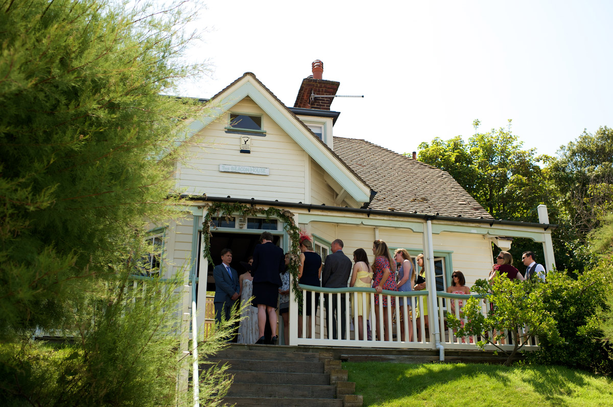 view of wedding party on veranda during wedding ceremony at the artists house in whitstable in kent