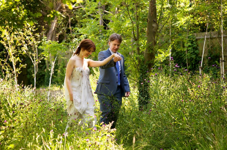 naomi and martin walk through the gardens behind the artists beach house in kent