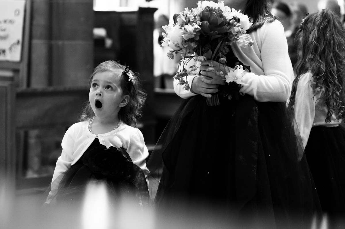 blacka nd white photograph of flower girl singing at kevin and emma church wedding in kent