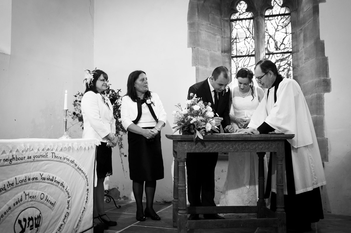 Bride and groom sign the wedding register in church