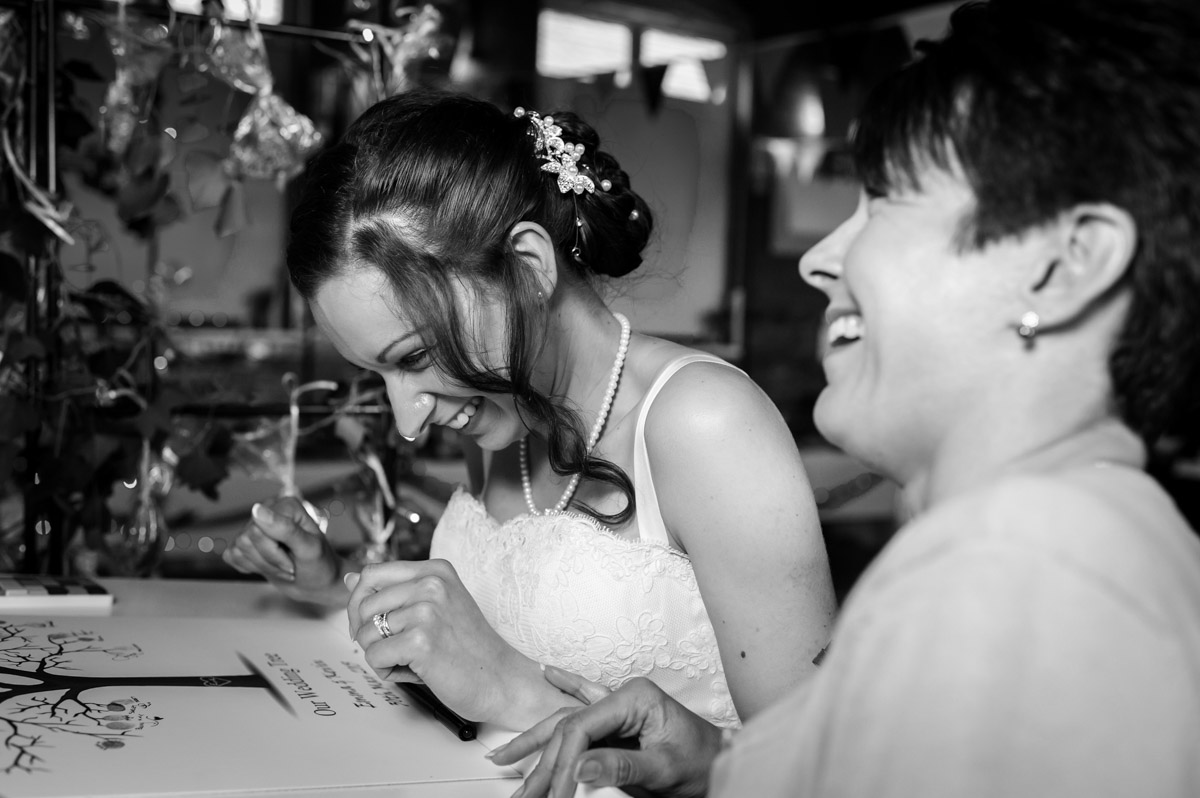 Bride and her sister share a joke at wedding reception