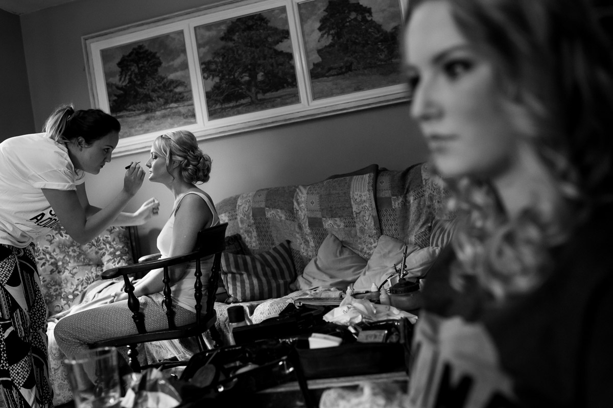Black and white Photo of bride getting ready for her wedding having make up applied