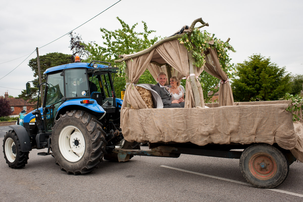 Couple driven to wedding reception in tractor and trailer