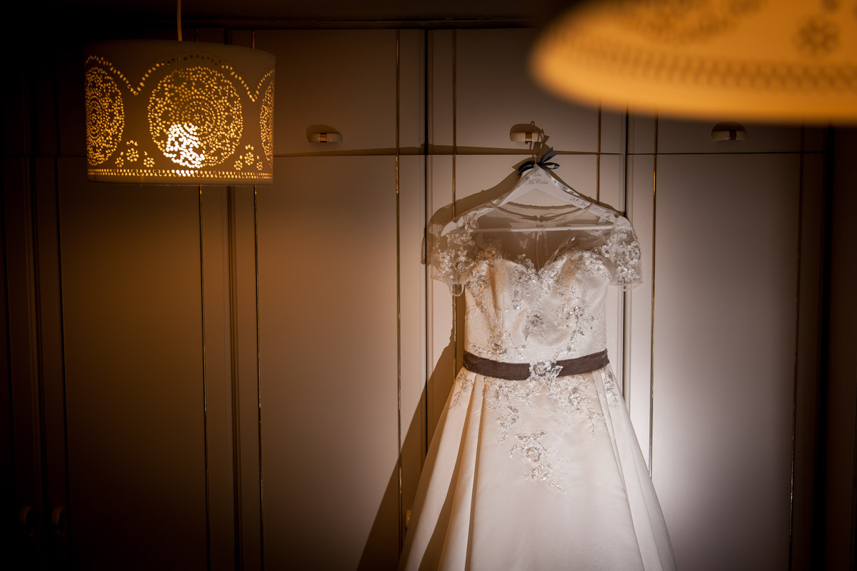 Creative photo of wedding dress hanging on wardrobe