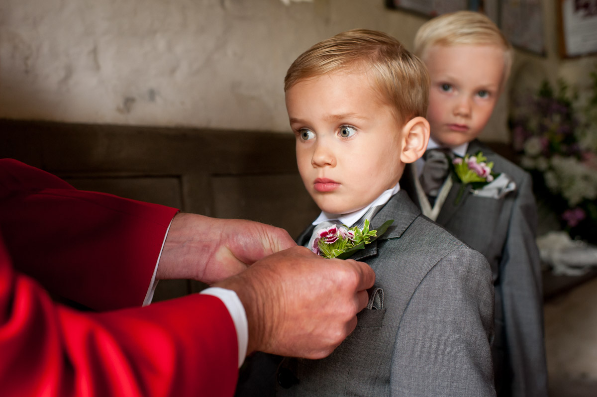 Photo of pageboy having his buttonhole put on