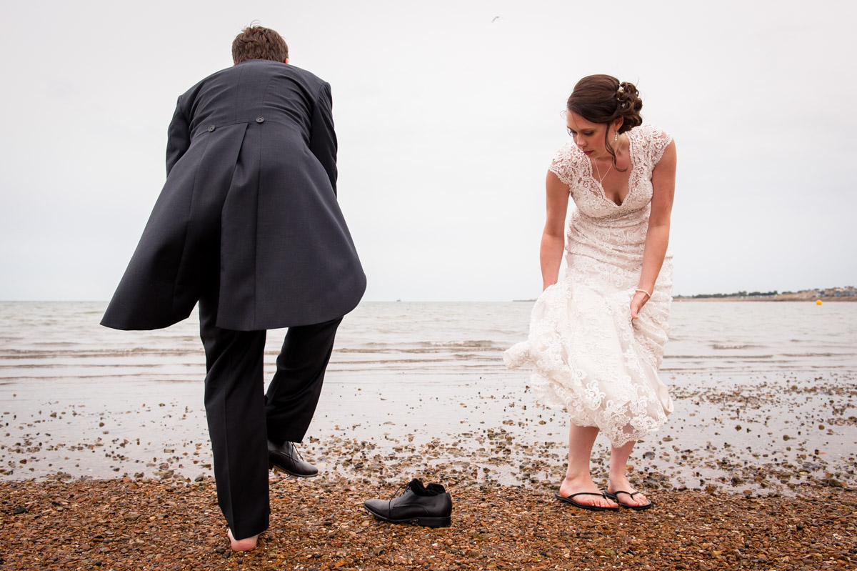 Photograph of Bride and Groom go paddling in the sea at Whitstable on their wedding day