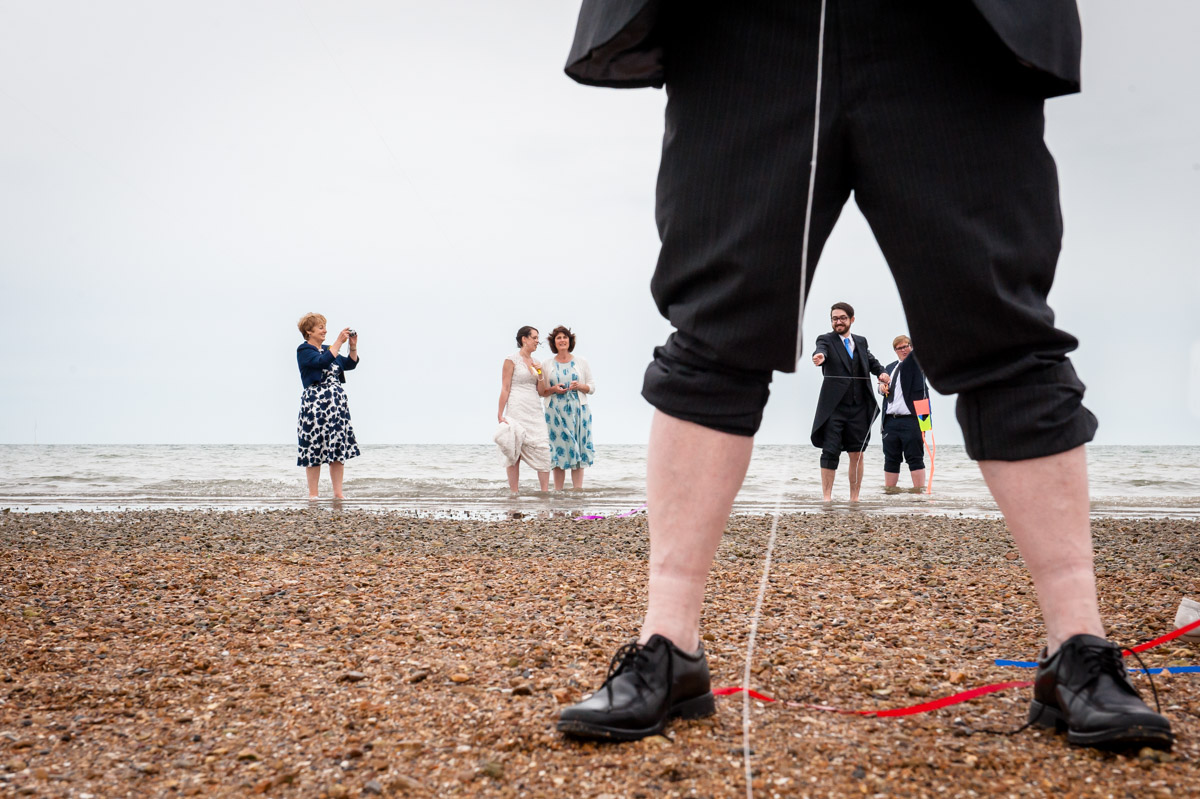 Wedding guests fly kites during Beacon House wedding by the sea in Kent